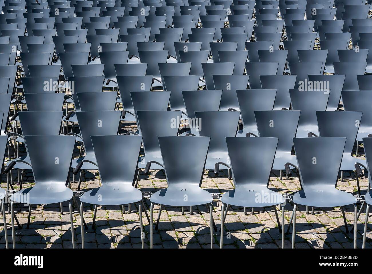 Reihen leerer Stühle in einem Freilichttheater. Hintergrund leerer Sitzplätze im Freien. Ein Muster aus grauen Sitzen. Stockfoto