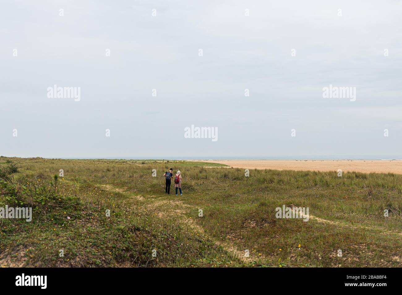 2 Personen zu Fuß entlang der Norfolk Küste Stockfoto