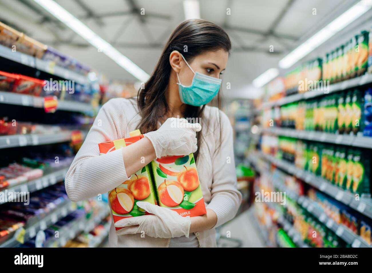 Natürliche Quelle von Vitaminen und Mineralstoffen.Apfelsaft Antioxidantien.Frau mit Gesichtsmaske Kauf im Supermarkt.Frau Vorbereitung auf Erreger Virus Pand Stockfoto