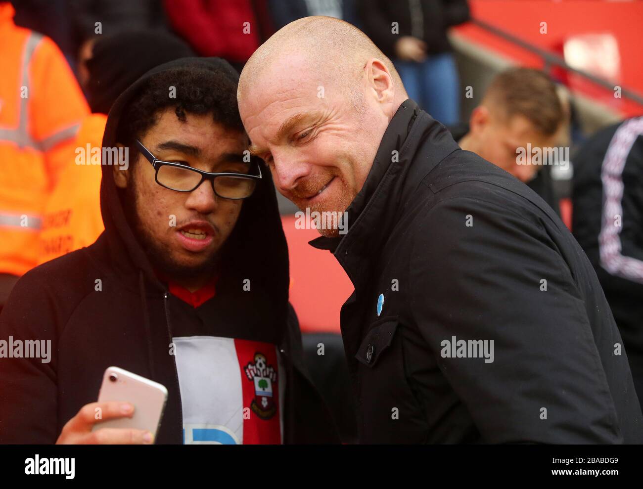 Burnley-Manager Sean Dyche posiert vor dem Anpfiff für ein Foto mit einem Fan Stockfoto