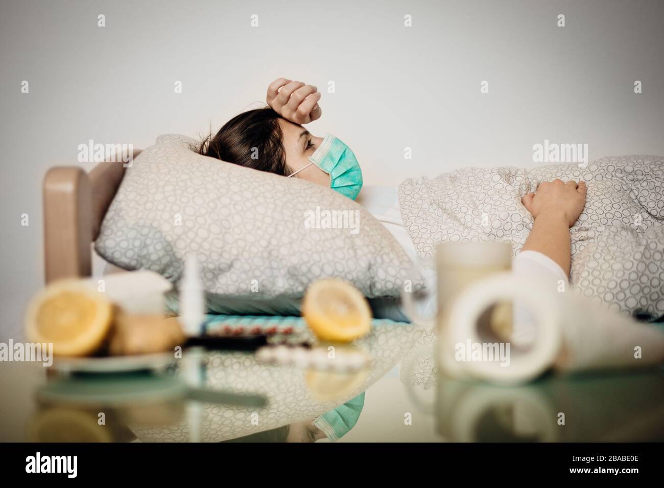 Kranke Frau mit Maske im Quarantänebett Selbstisolierung.Coronavirus Covid-19 Patient mit Pneumonie Krankheitssymptome.Prävention und Gesundheitspflege behandeln Stockfoto