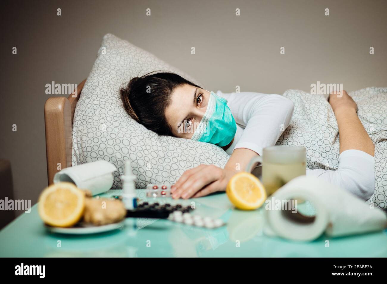 Kranke Frau in der Wohnung Quarantäne Bett Selbstisolierung.schwere Pneumonie Krankheit.Grippe infizierte Patienten mit Maske, die an Symptomen von Coronavirus illnes leidet Stockfoto