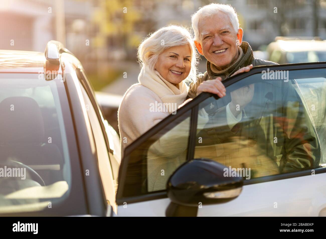 Glückliches älteres Paar mit ihrem neuen Auto Stockfoto