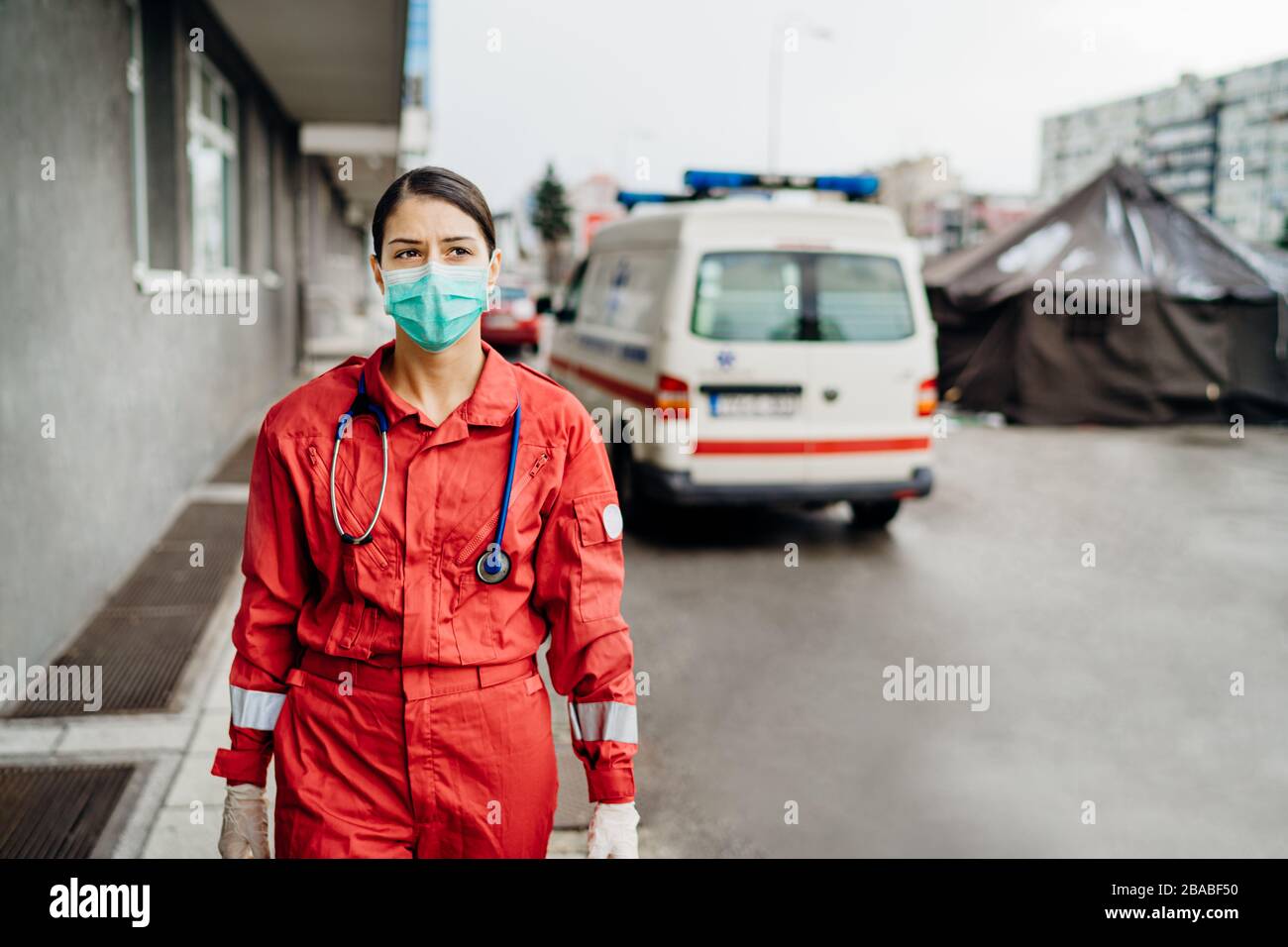 Trauriger überarbeiteter Sanitäter in Uniform vor der Isolationsanstalt.Notarzt in Angst und psychischem Stress,Kampfdruck Stockfoto