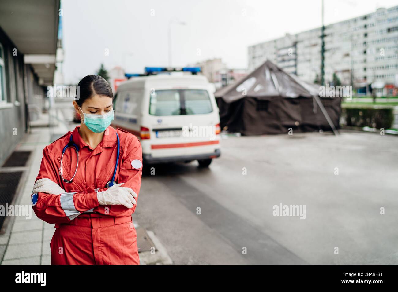 Trauriger überarbeiteter Sanitäter in Uniform vor der Isolationsanstalt.Notarzt in Angst und psychischem Stress,Kampfdruck Stockfoto