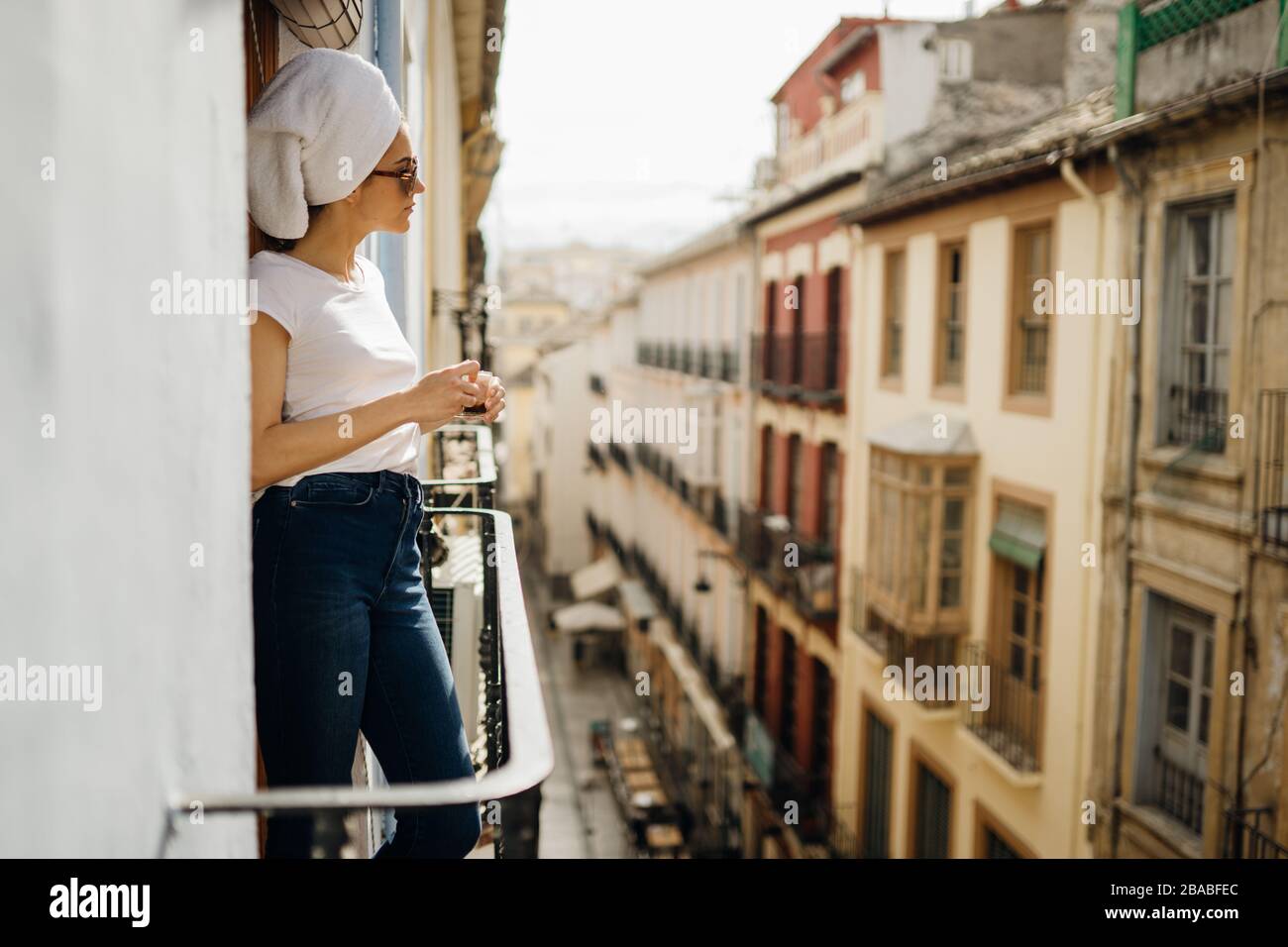 Junge europäische Frau, die Zeit für einen Kuraufenthalt zu Hause verbringen.Selbstversorgung,zu Hause bleiben.Blick auf den Balkon genießen.zu Hause entspannen.Zimmer mit Balkon Stockfoto