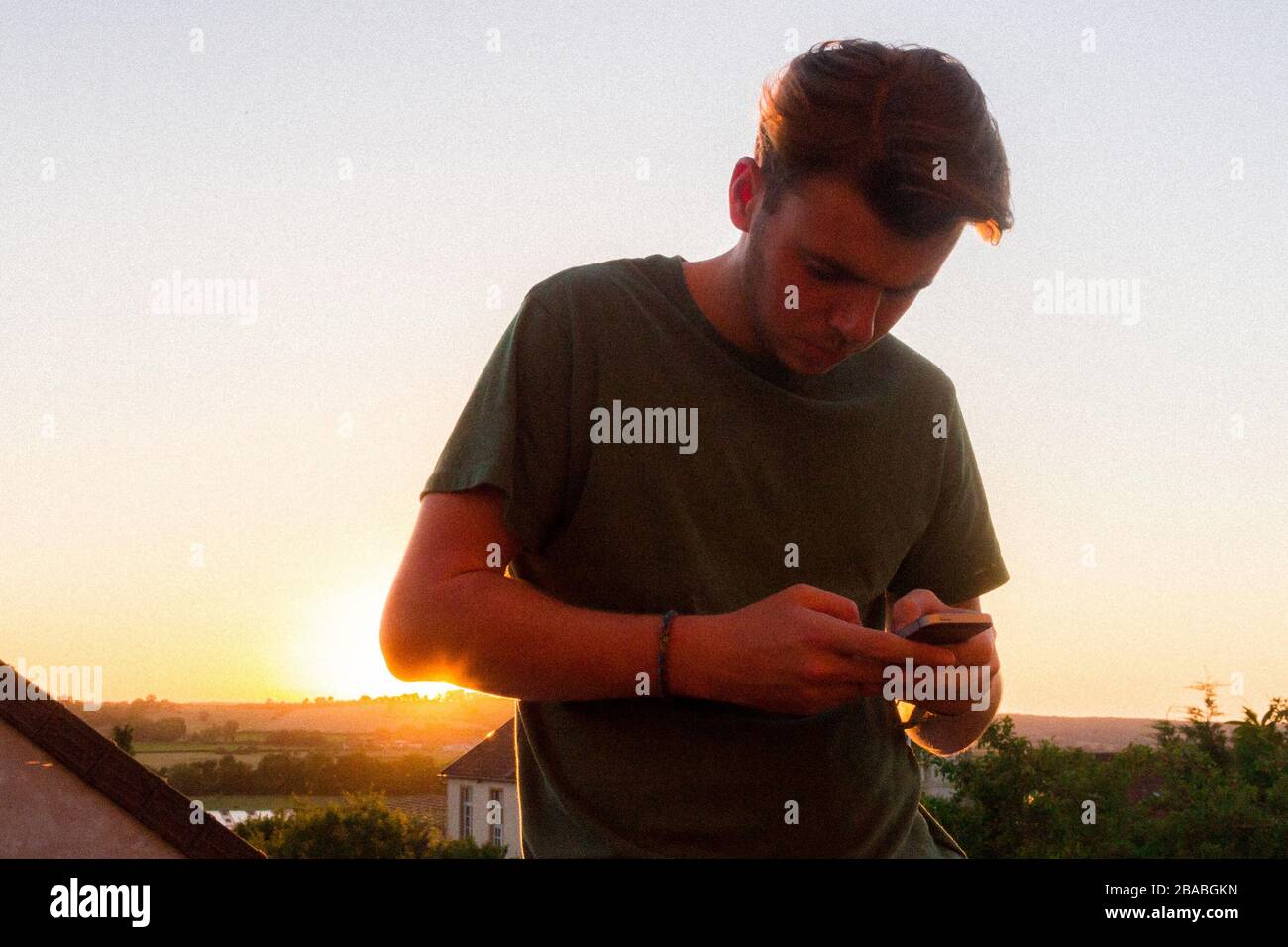 Junger Mann Am Telefon, Als Die Sonne In Burgundy, Frankreich, Hinterhergeht Stockfoto