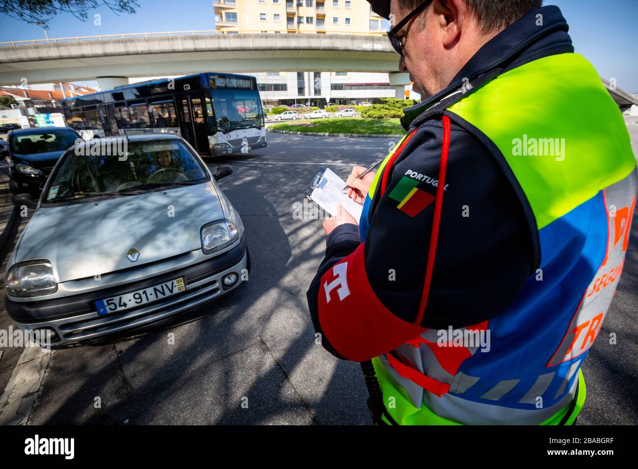 Ein Polizeibeamter nimmt das Kennzeichen und den Führerschein zur Kenntnis.in der Stadt Porto überwachen bereits mehrere Polizeibeamte, die auf der Straße nach den neuen, von der Regierung festgelegten Regeln ausfahren. Nach der Erklärung eines Ausnahmezustands aufgrund der drohenden Coronavirus-Pandemie. Stockfoto