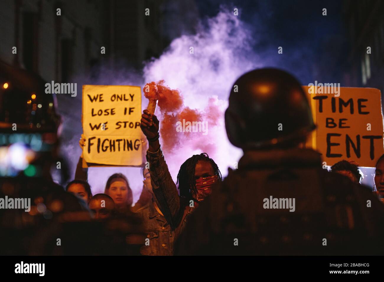 Gruppe von Aktivisten protestiert nachts mit Rauchgranaten. Eine Gruppe von Männern und Frauen, die gegen die Regierung protestieren. Stockfoto