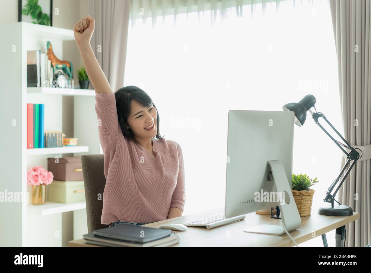 Schöne asiatische Geschäftsfrau arbeitet von zu Hause aus und feiert mit Computer, Erfolg fröhliche Pose. E-Commerce, Hochschulbildung, Internet-Technologie, Stockfoto