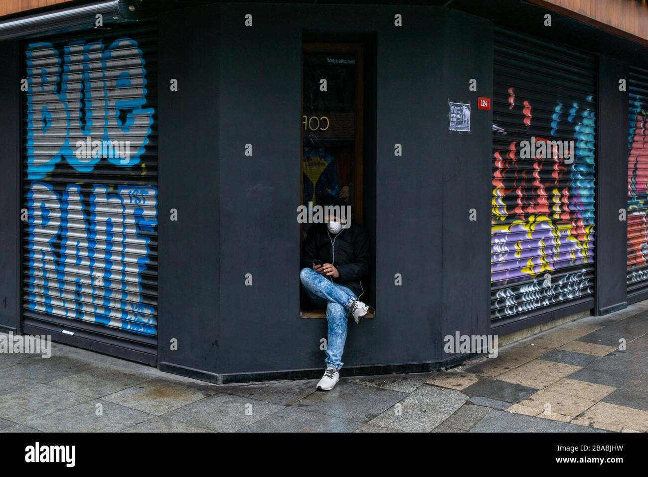 Ein einziger Mann trägt eine Maske an der Ecke der leeren Kadikoy-Straße. Stockfoto