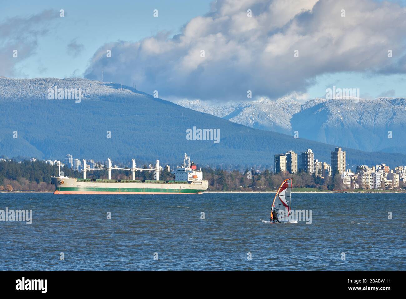 Windsurfen In English Bay. Ein Windsurfer an der English Bay am Morgen. Im Hintergrund sind die North Shore Mountains. Vancouver, British Columbia, Can Stockfoto