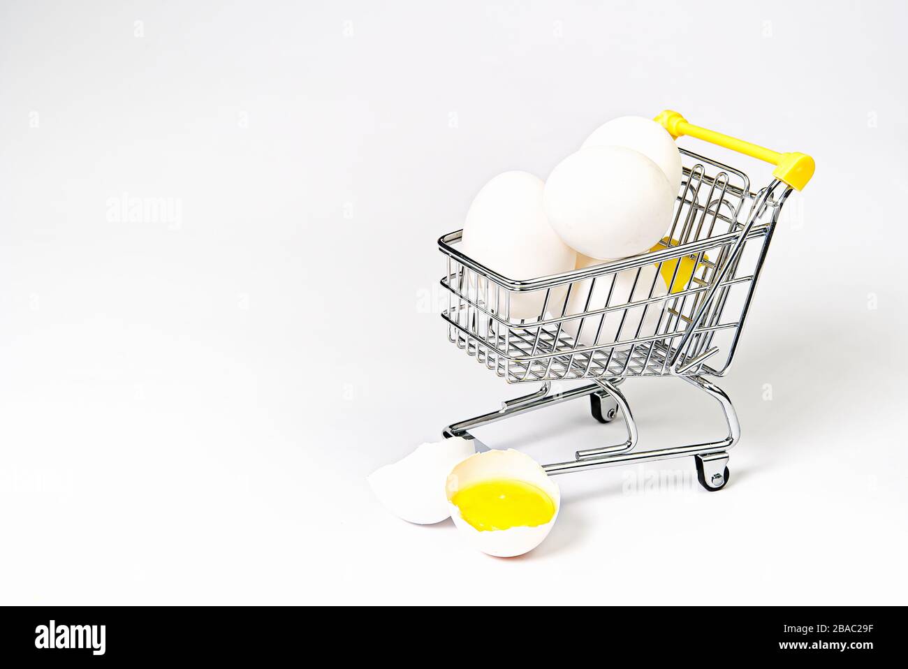 Huhn weiße Eier in einem Einkaufswagen. Zerbrochenes Hühnchen weißes Ei. Isoliert auf Weiß Stockfoto