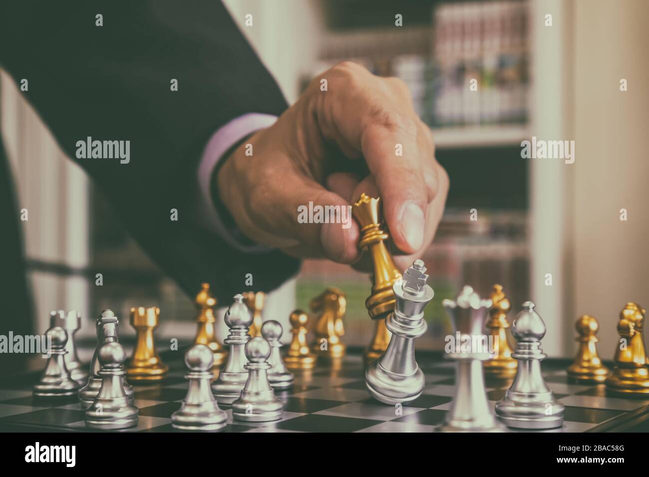 Schachspiel auf Schachbrett hinter dem Hintergrund des Geschäftsmannes. Geschäftskonzept zur Präsentation von Finanzinformationen und Analysen der Marketingstrategie. Investitionen Stockfoto