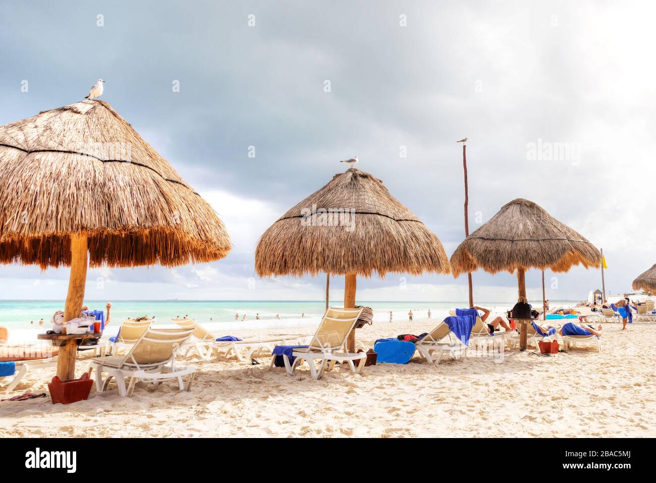 Unerkennbare Strandgänger strömen während des beliebten Winterausflugens zur karibischen Küste zu den tropischen Stränden der Riviera Maya in der Nähe von Cancun, Mexiko. Stockfoto