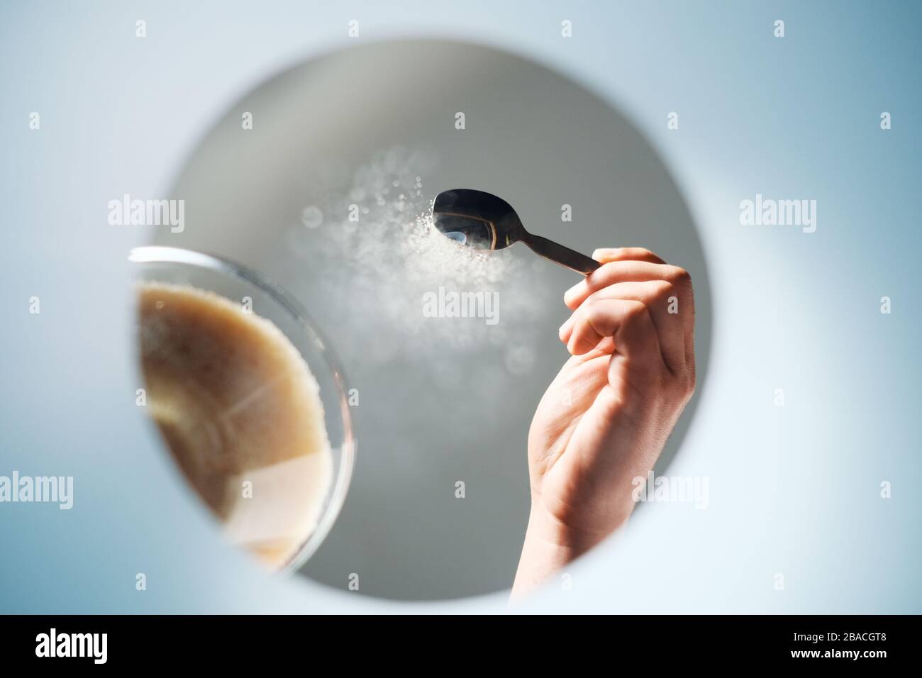 Mann, der dem Kaffee Zucker zufügt, von innen BETRACHTET EINE Tasse Stockfoto