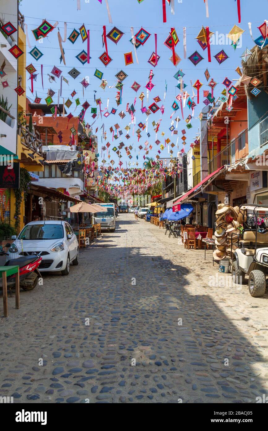 Der bunte Ojo de dios streunte über eine Kopfsteinpflasterstraße in der Stadt Sayulita, Mexiko, Nayarit. Stockfoto