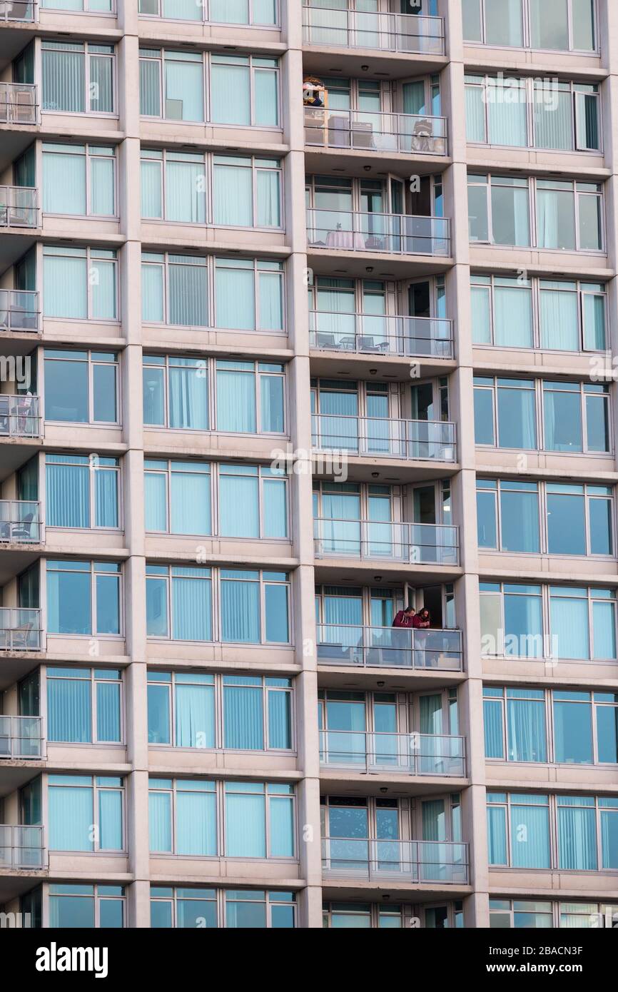 DOWNTOWN VANCOUVER, BC, KANADA - 24. März 2020: Ein Paar, das sich selbst zerstritten, kommt um 19 Uhr auf ihren Balkon, um die kanadische Gesundheitsversorgung zu bejubeln Stockfoto