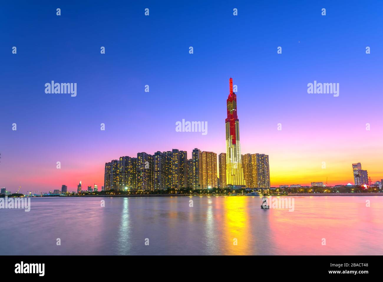 Bunte Sonnenuntergangslandschaft in einem urbanen Gebiet am Fluss mit Wolkenkratzern, die die wirtschaftlichste Entwicklung in Ho-Chi-Minh-Stadt in Vietnam zeigen Stockfoto