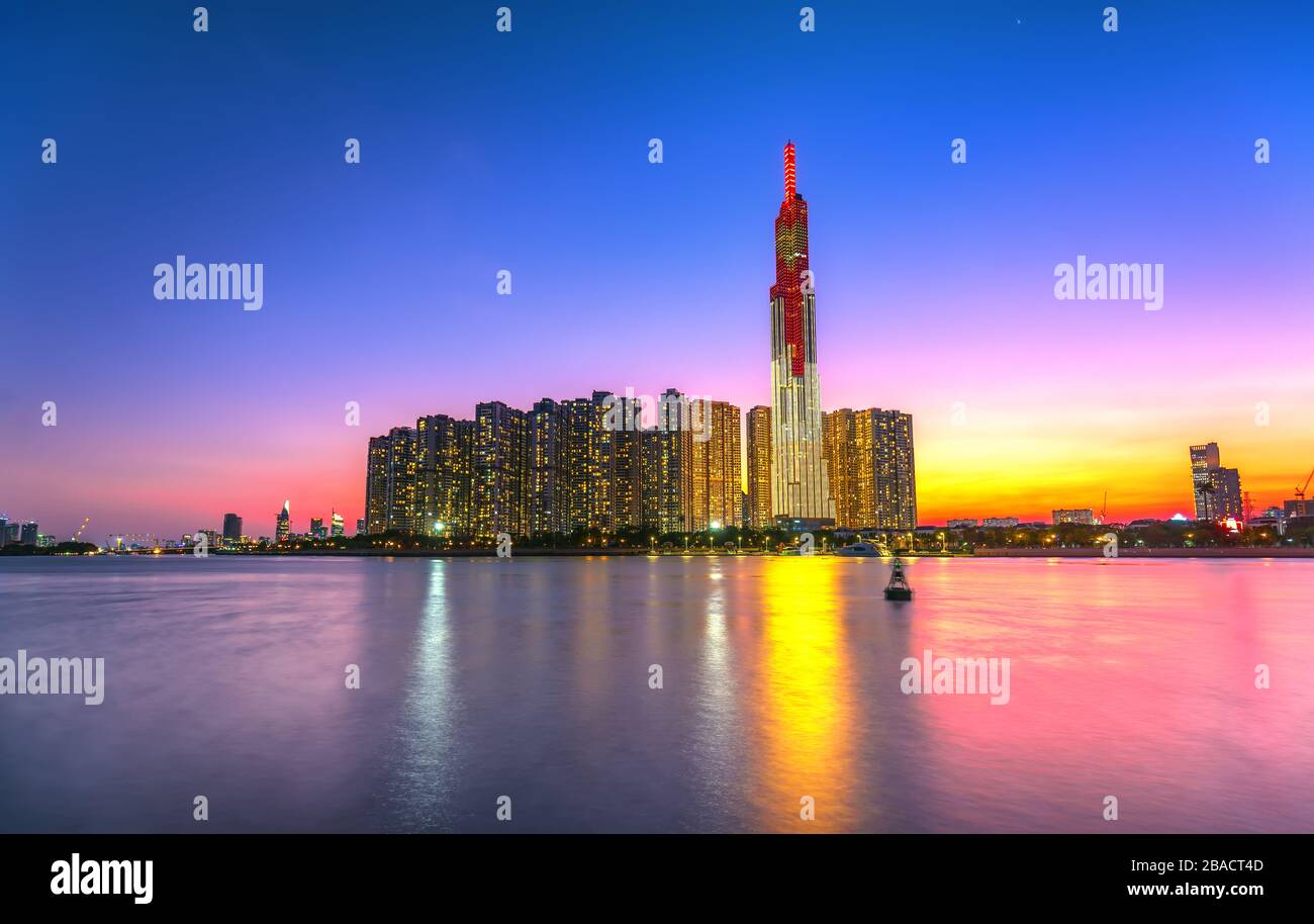Bunte Sonnenuntergangslandschaft in einem urbanen Gebiet am Fluss mit Wolkenkratzern, die die wirtschaftlichste Entwicklung in Ho-Chi-Minh-Stadt in Vietnam zeigen Stockfoto