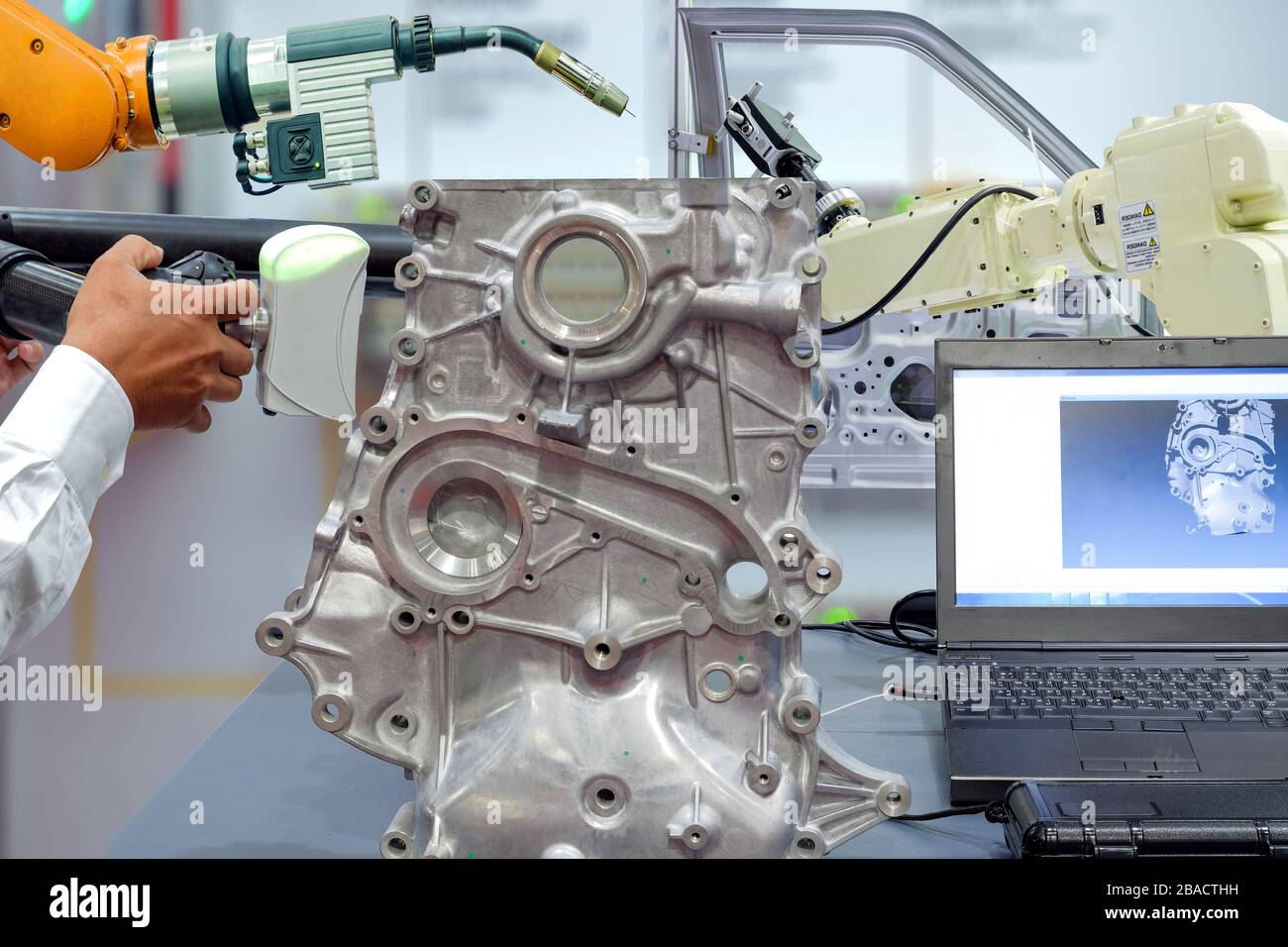 Nahanhänder von Techniker und Robotern verwenden 3D-Scan zum Scannen von Auto-Teilen auf dem Display des Laptops und zum Roboterschweißen zum Standby für Arbeit Stockfoto