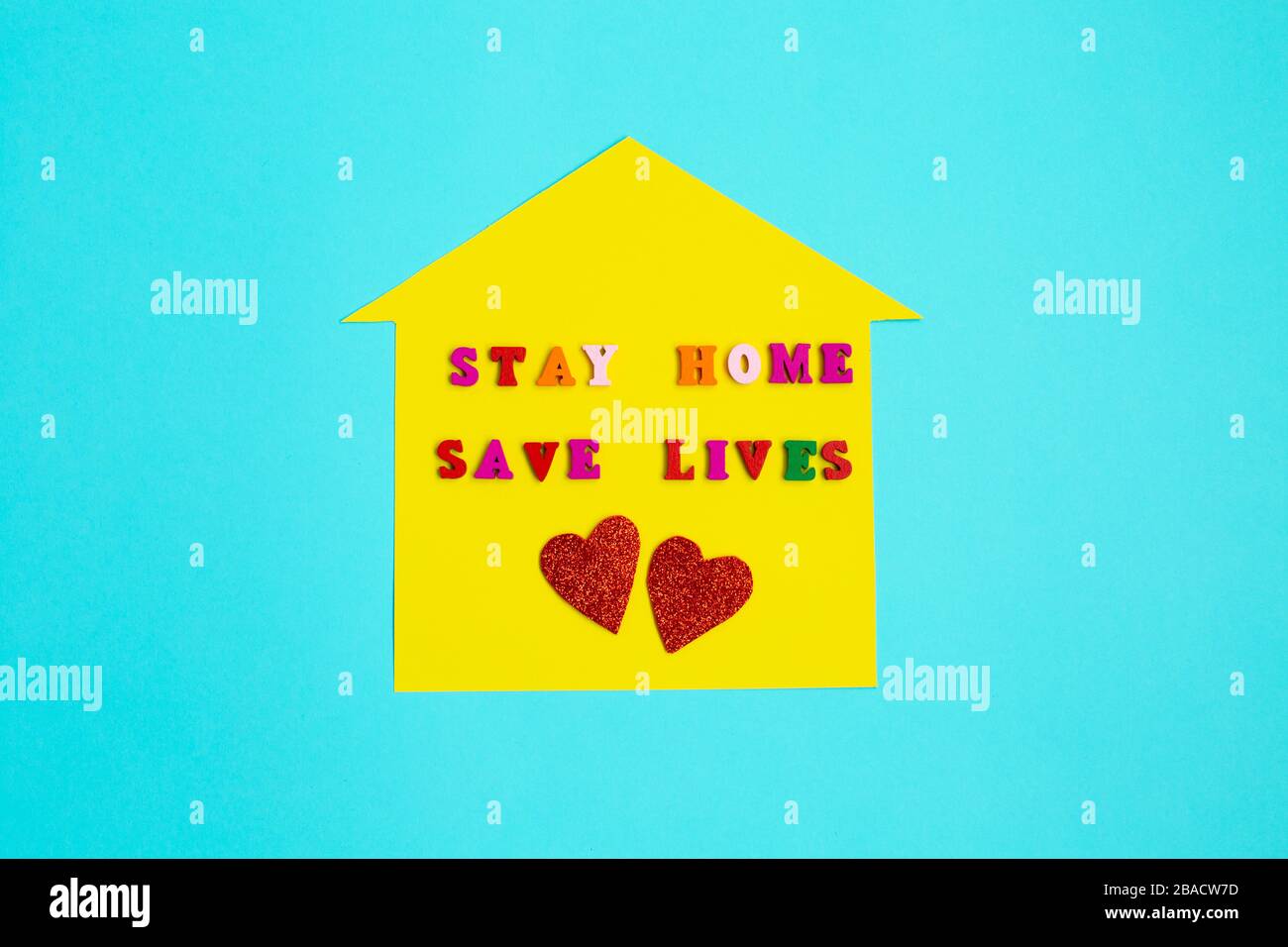 "Stay Home Save Lives"-Phrase auf gelbem Heimhintergrund. Bleiben Sie sicher, und bleiben Sie zuhause. Retten Sie den Planeten vor dem Corona-Virus. Stockfoto