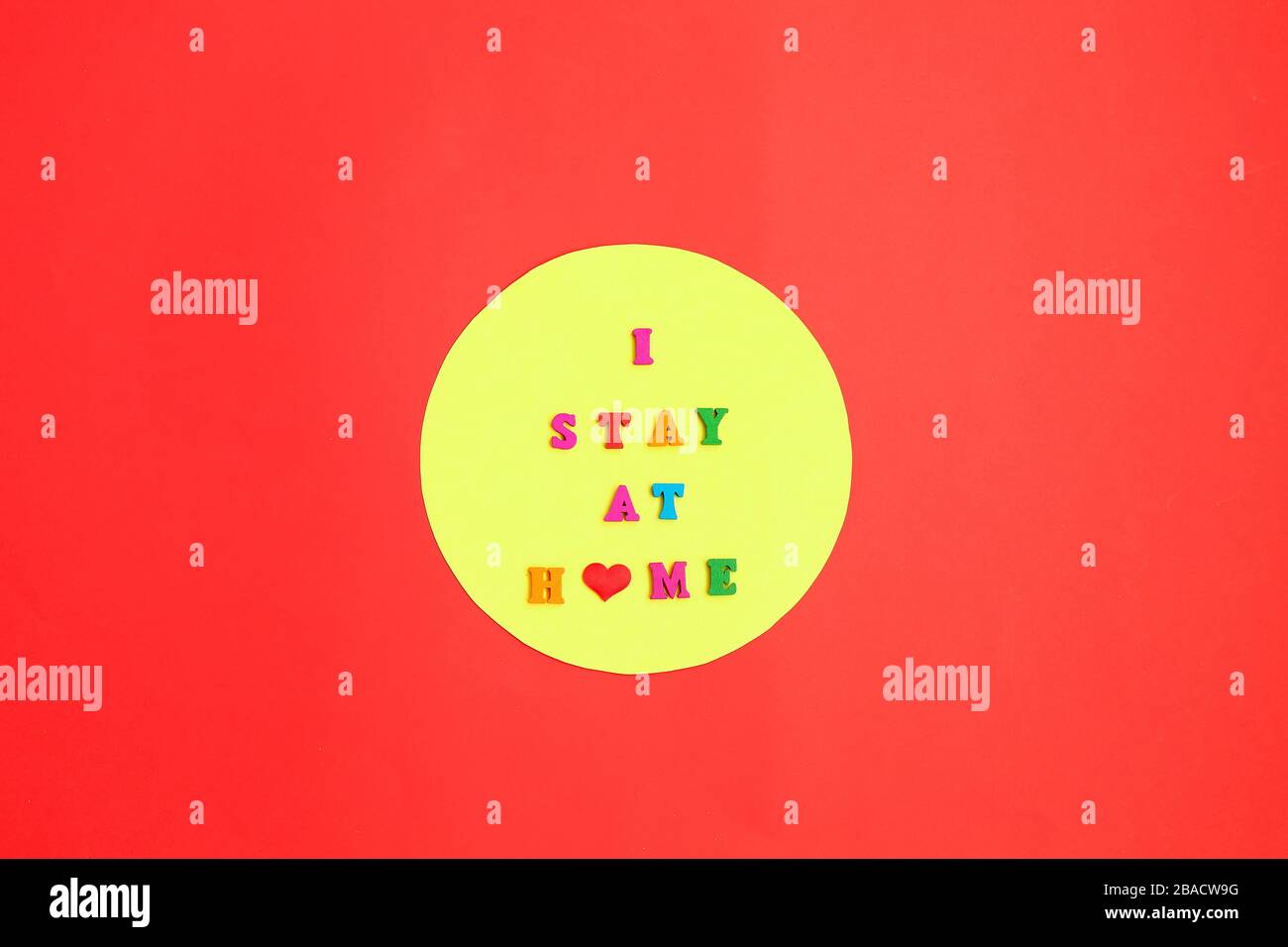 Ich bleibe zu Hause auf rotem Hintergrund. Bleiben Sie sicher, und bleiben Sie zuhause. Retten Sie den Planeten vor dem Corona-Virus. Stockfoto
