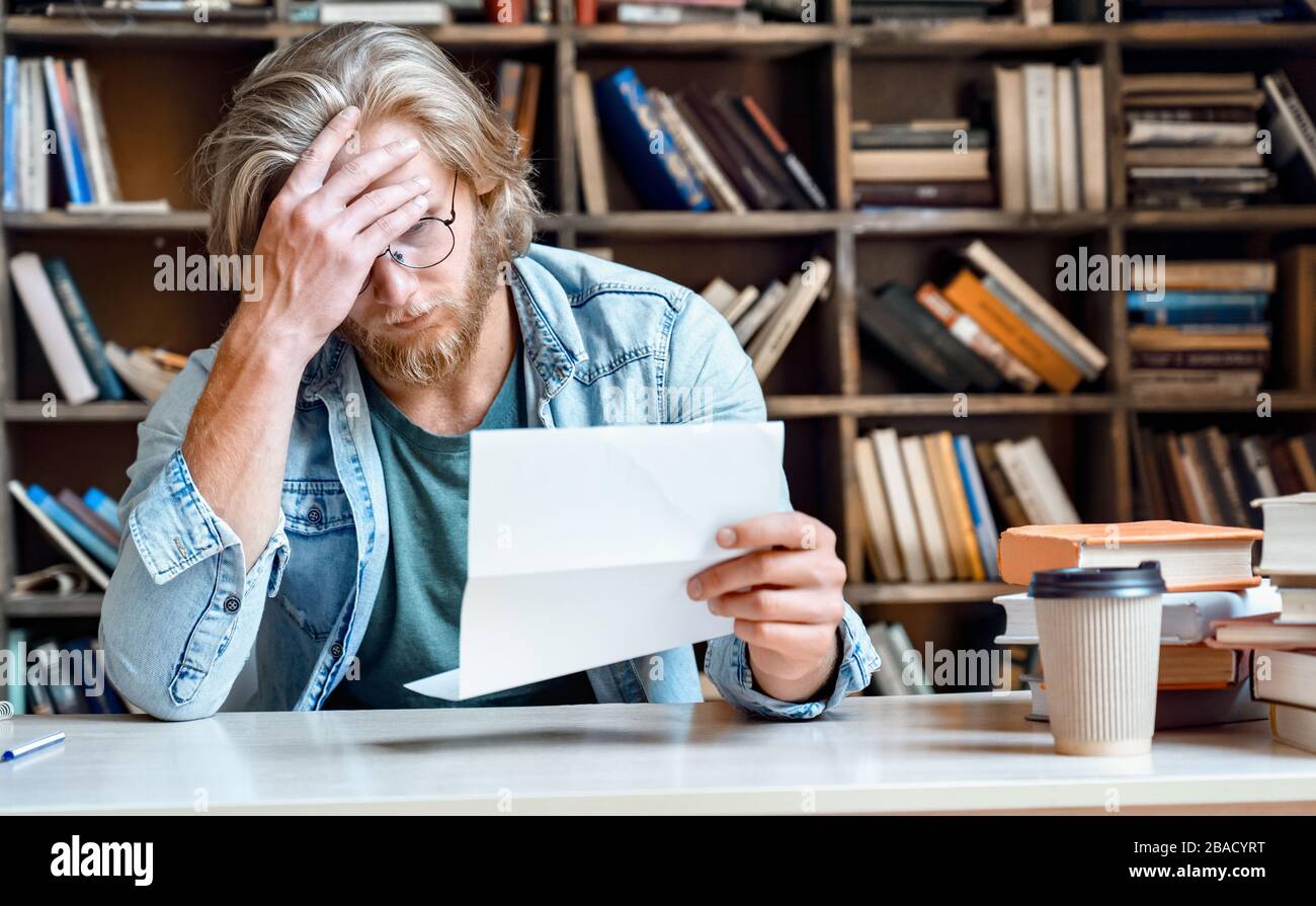 Frustriert depressiv verzweifelte junge Geschäftsmann lesen Brief. Stockfoto