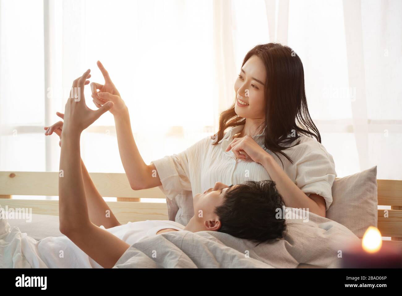 Glückliches junges Paar im Bett träumt von neuem Leben Stockfoto
