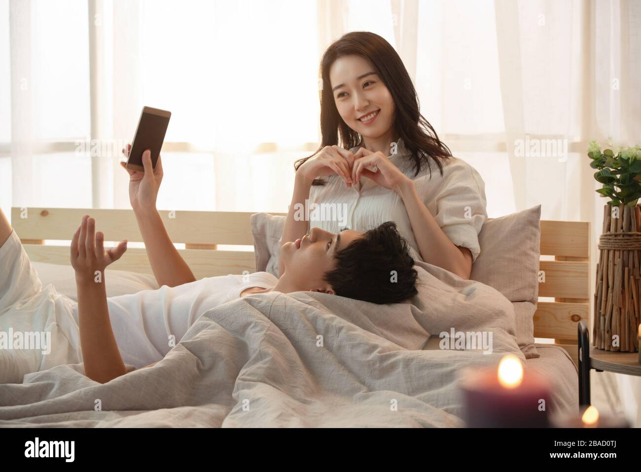 Glückliches junges Paar im Bett träumt von neuem Leben Stockfoto
