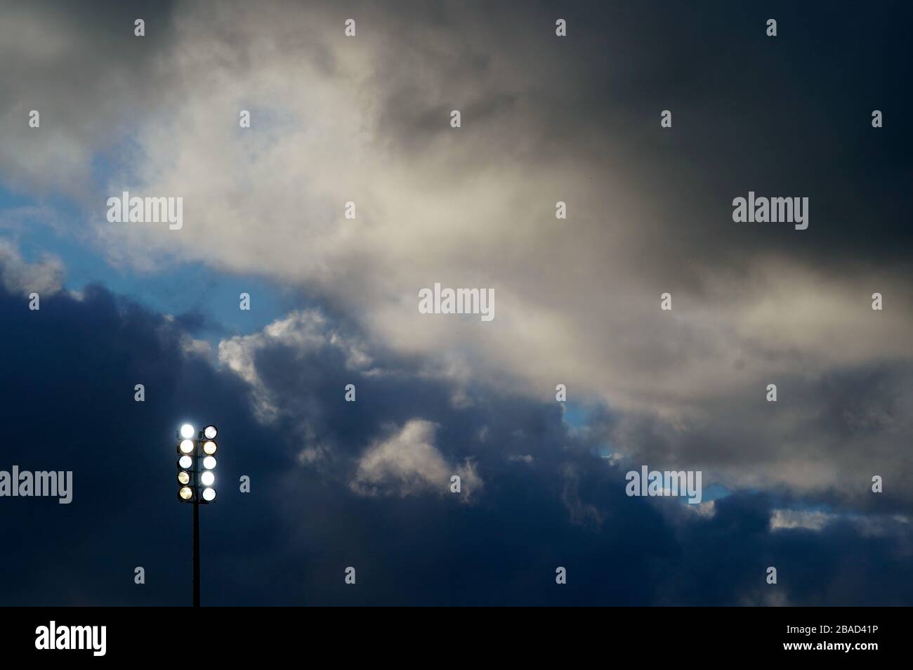 Allgemeiner Blick auf dunkle Wolken über einem Flutlicht Stockfoto