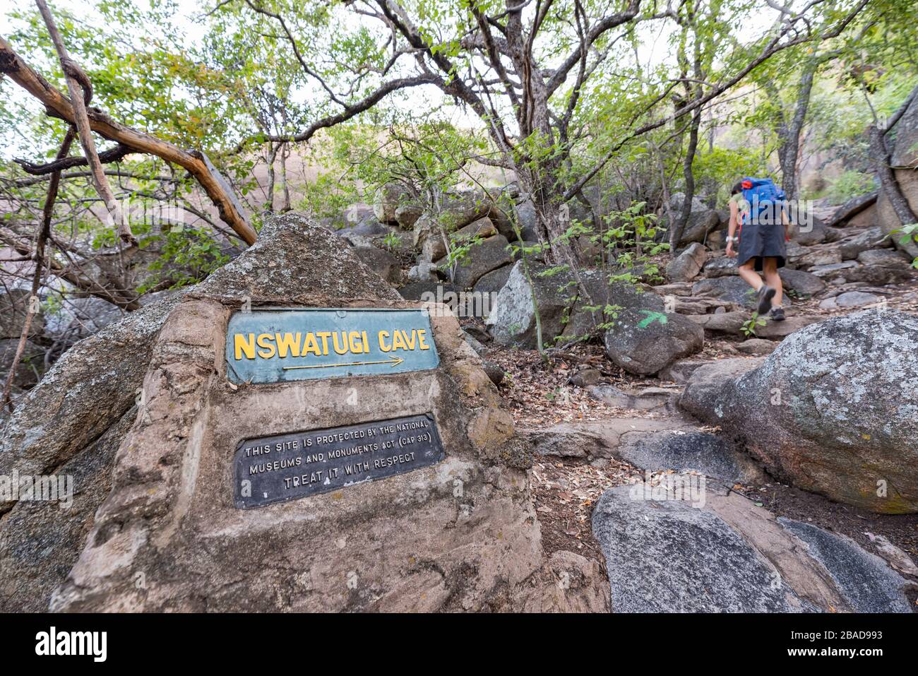 Ein Tourist klettert auf einen Hügel zur Nswatugi Höhle im Matobo Nationalpark Simbabwe. Stockfoto