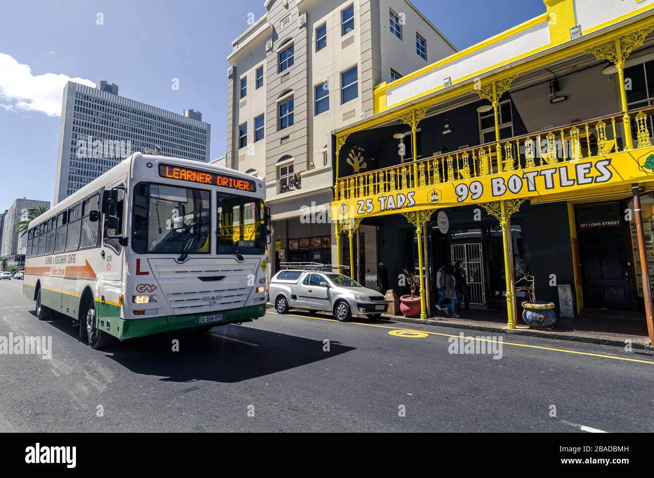 Afrikanischer Bus- und Learner-Fahrer beleuchtete vor dem Bus, der das Bierhaus auf der langen Straße von Kapstadt-Südafrika passiert Stockfoto