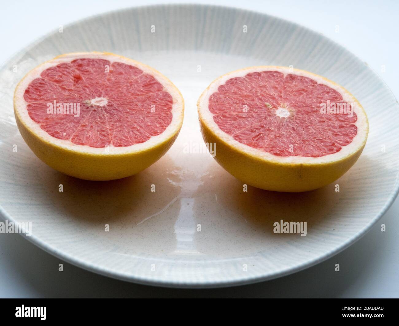Eine in Scheiben geschnittene Grapefruit auf einem Teller Stockfoto