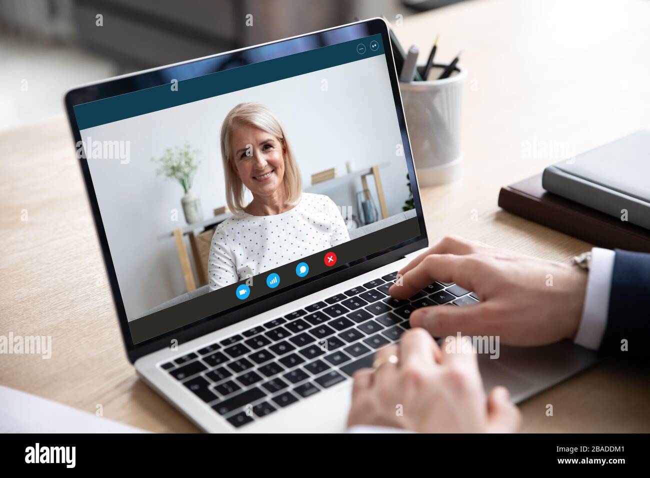 Alte Frau hält Videoanruf mit männlichem Geschäftspartner. Stockfoto