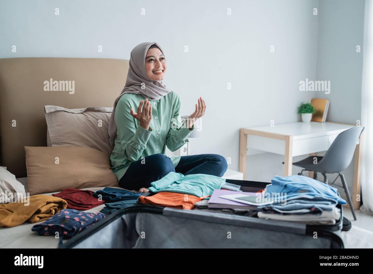 Muslimische Frauen danken Gott, nachdem sie ihre Kleidung vorbereitet haben, bevor sie in den Urlaub gehen Stockfoto