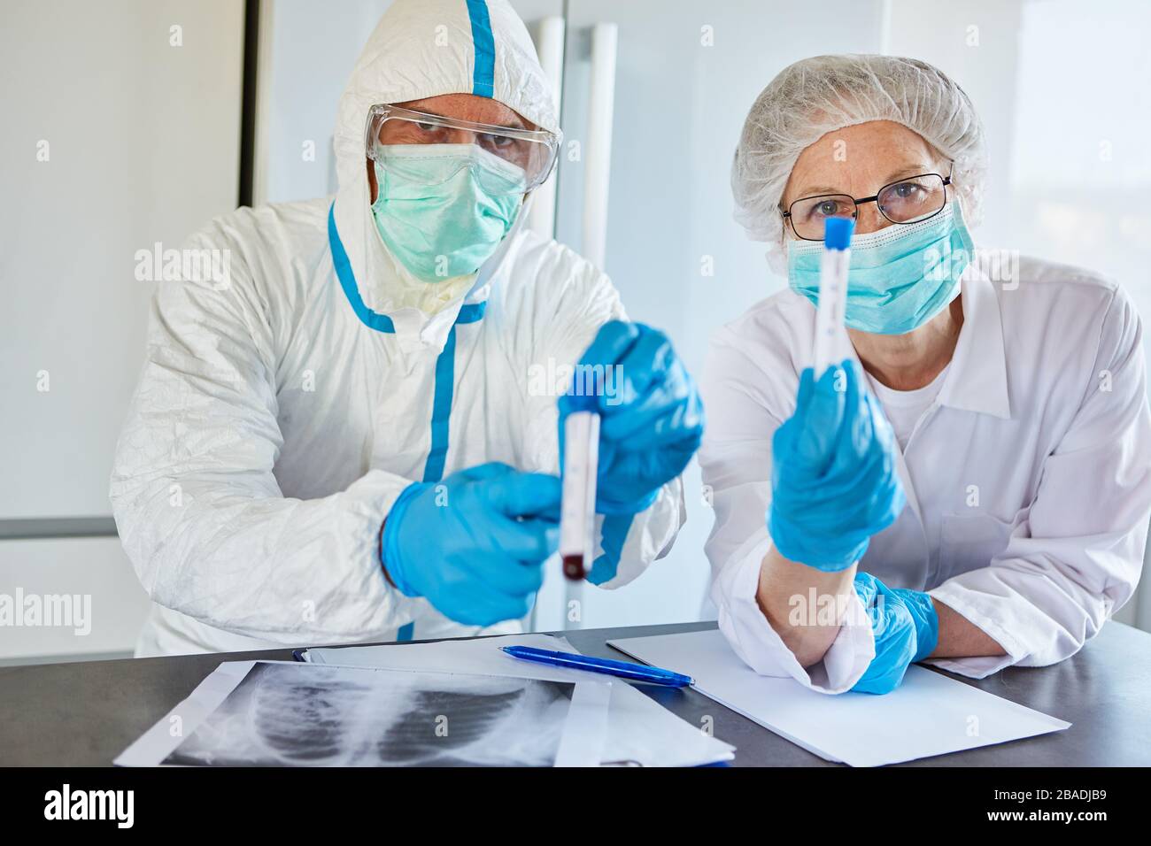 Radiologen in Schutzkleidung in der Klinik mit Blutproben von Covid-19-Patienten Stockfoto