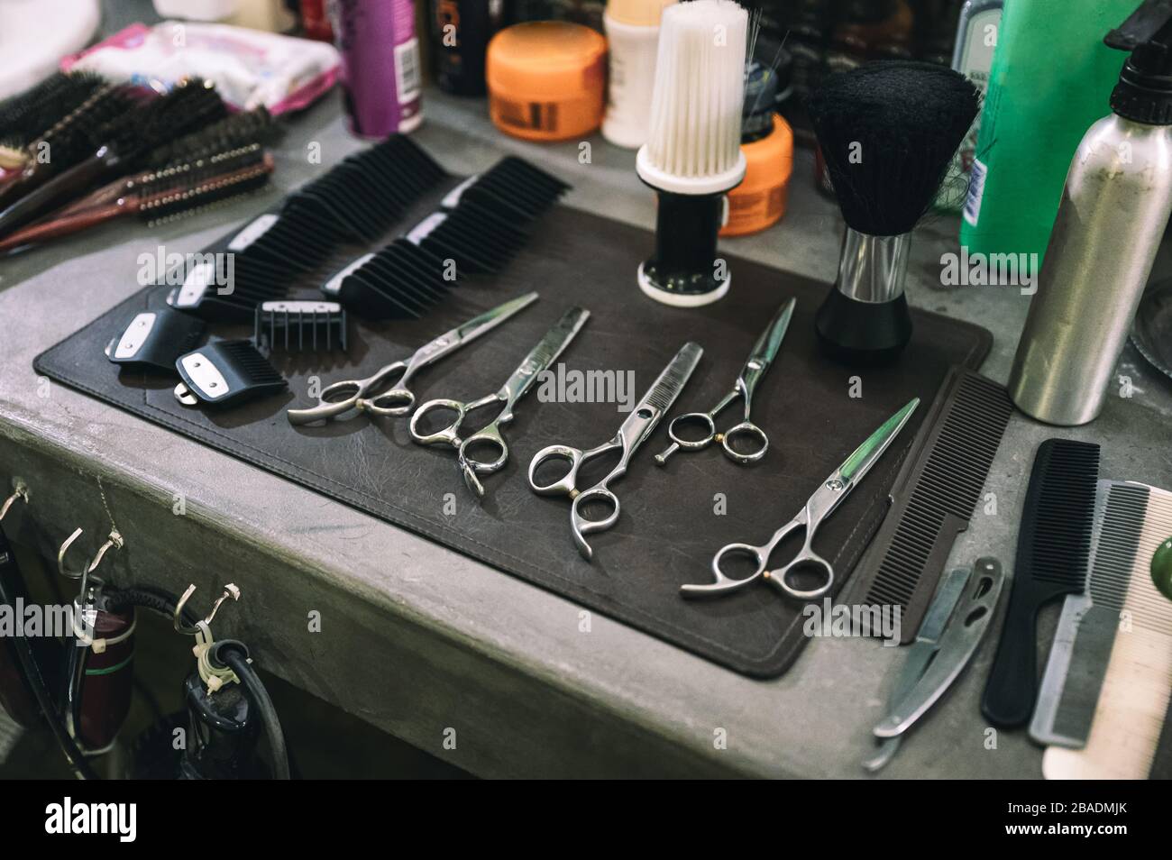 Werkzeuge zum Schneiden von Haaren mit Schere, Haarbürste und Kamm auf dem Tresen im Barbershop Stockfoto
