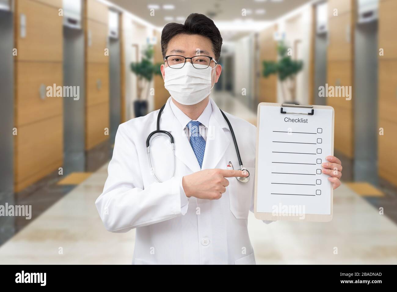 Asiatischer Mittelalter-Arzt mit einer Zwischenablage im Krankenhaus. Stockfoto