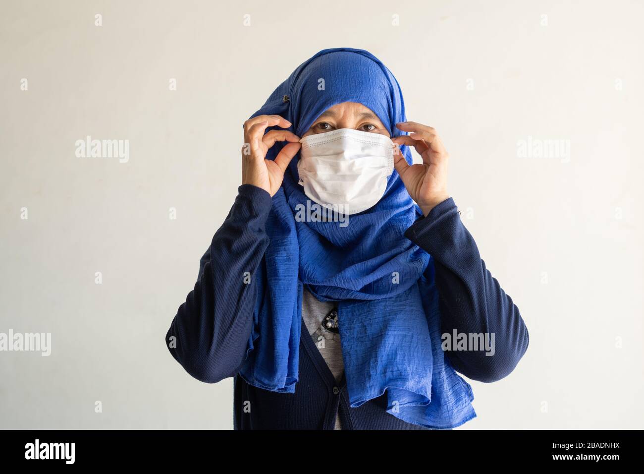 Asian Woman in der medizinischen Maske Coronavirus Pandemie-Krankheit isolieren Hintergrund. COVID-19-Virus von malaysischer Epidemie bis hin zu globaler, indonesischer Konce Stockfoto