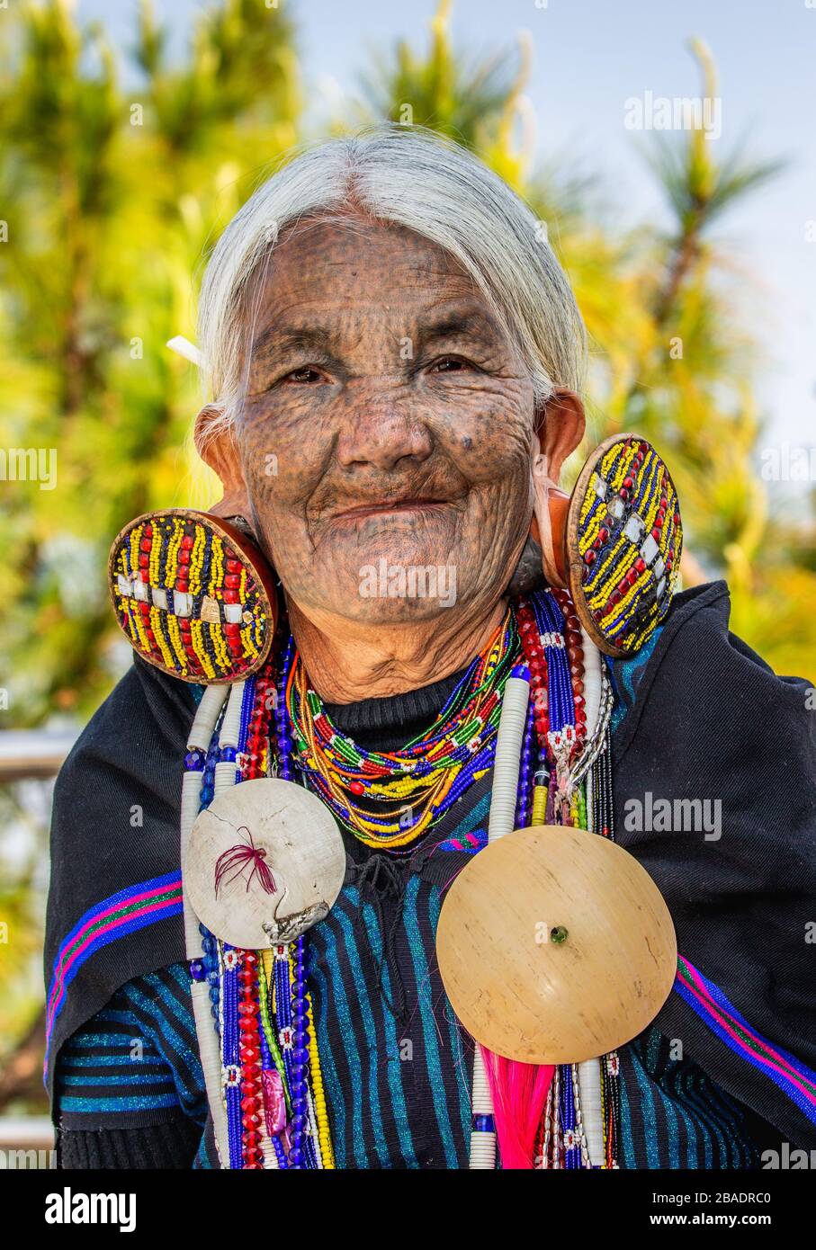 Porträt einer alten Kinnfrau im traditionellen Kleid mit traditionellem Schmuck. Februar 2019 In Myanmar Statt. Stockfoto