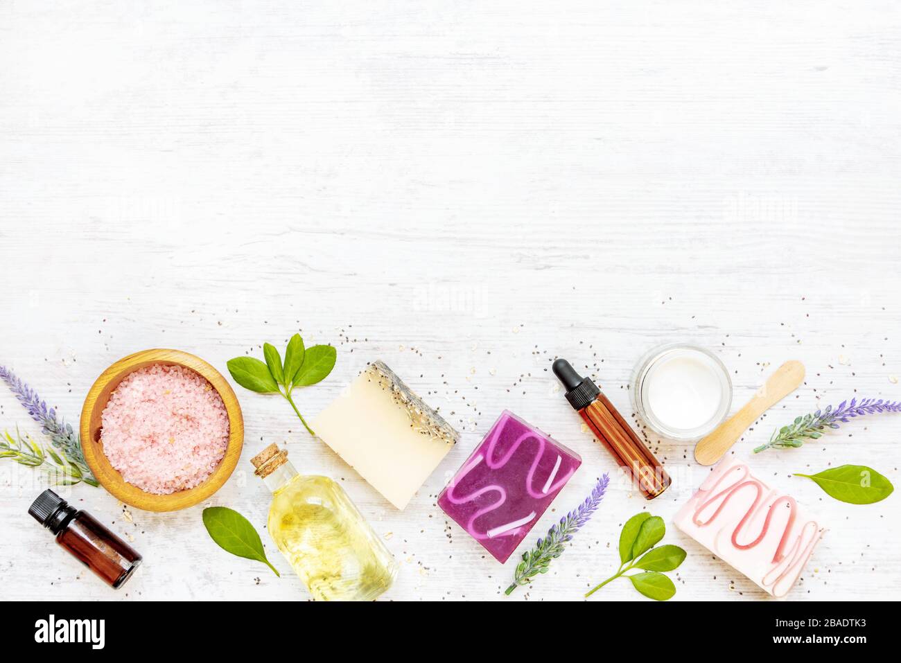 Draufsicht auf organische Seifen und Kosmetik mit Lavendel, Kräutern, chia und ätherischen Ölen. Weißer rusrischer Hintergrund, Kopierbereich. Stockfoto