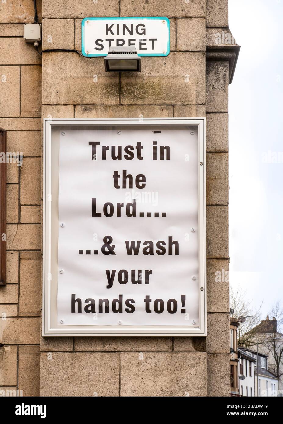 Wayside Puilpit an der Außenseite der Kirchenmauer - liest - Vertrauen in den Herrn ...& waschen Sie auch Ihre Hände! Stockfoto