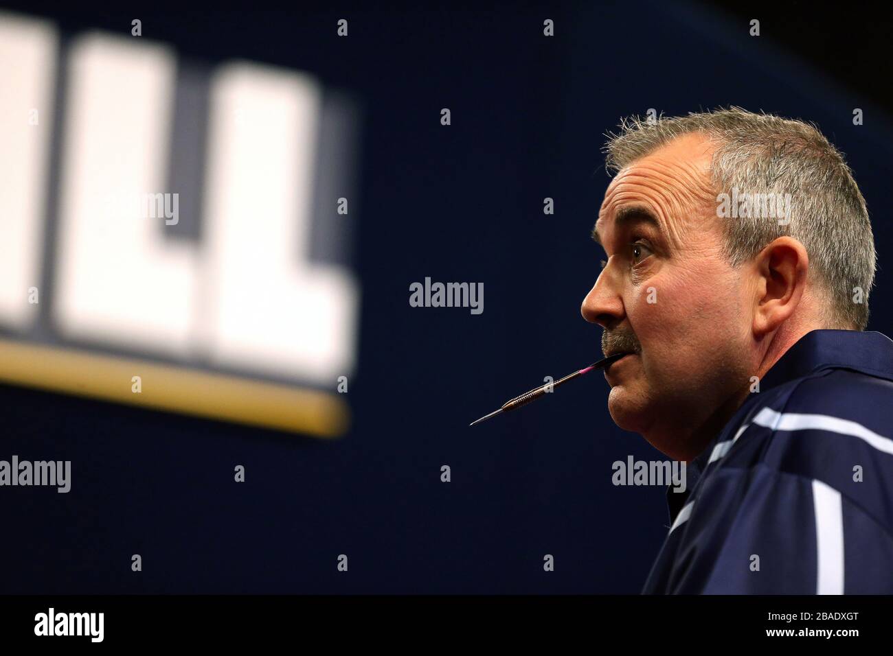 Phil Taylor hält einen Dart im Mund Stockfoto