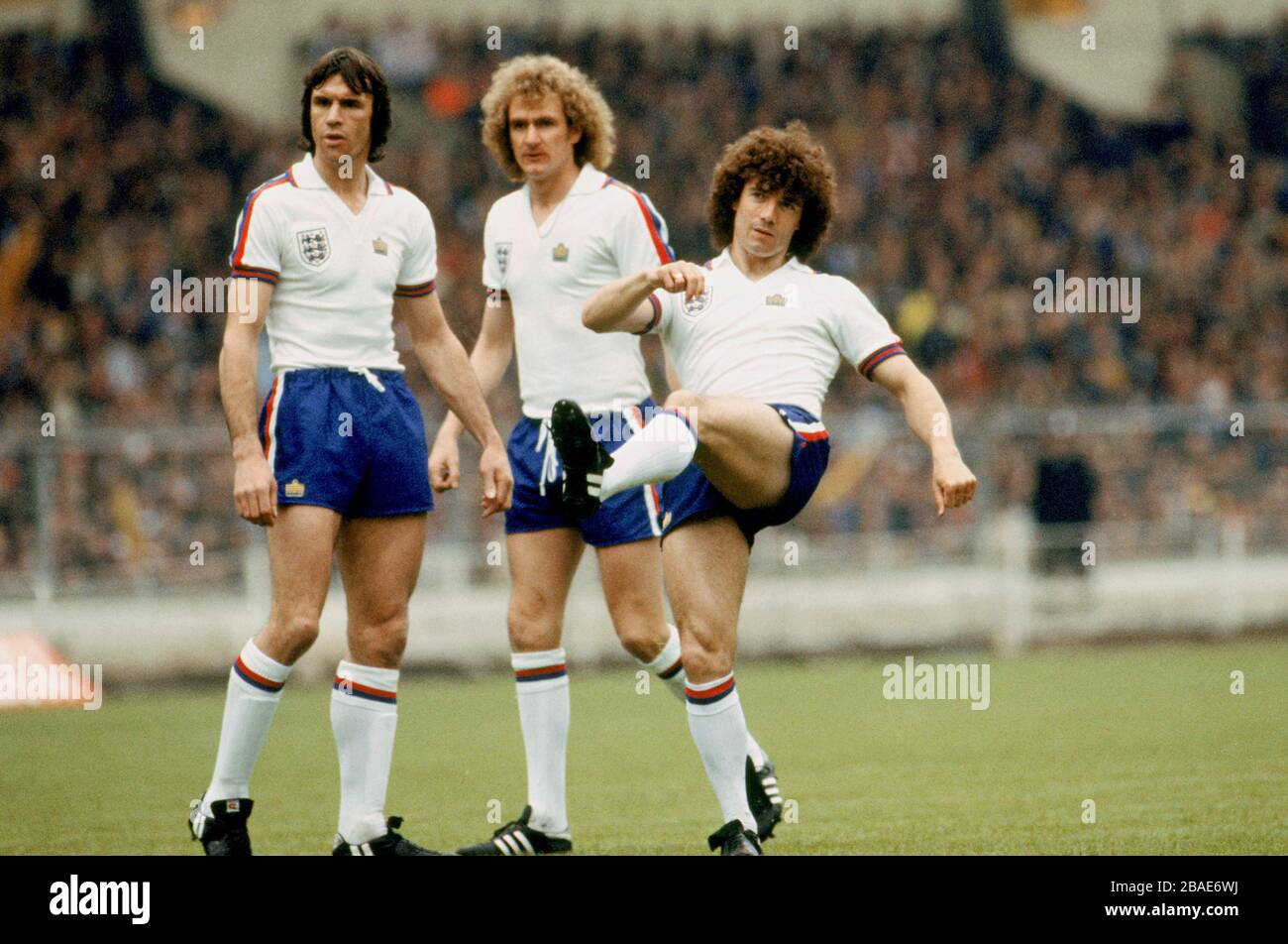 Englands Kevin Keegan (r) feuert einen Freistoß ins Tor, beobachtet von Teamkollegen Dave Watson (l) und Phil Thompson (c) Stockfoto