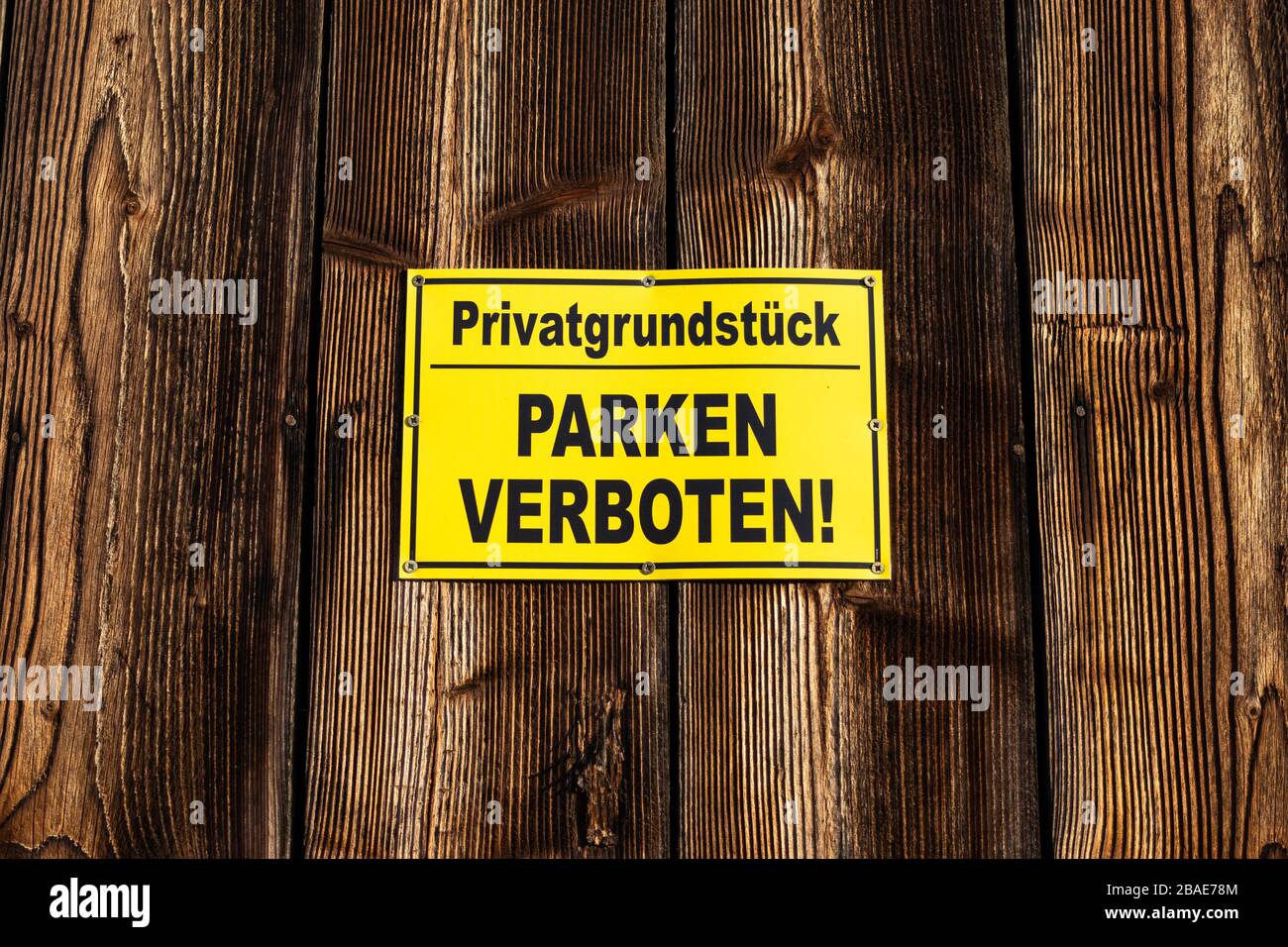 Alter Holzhintergrund mit Schild mit Parkplatz auf Deutsch verboten. Stockfoto