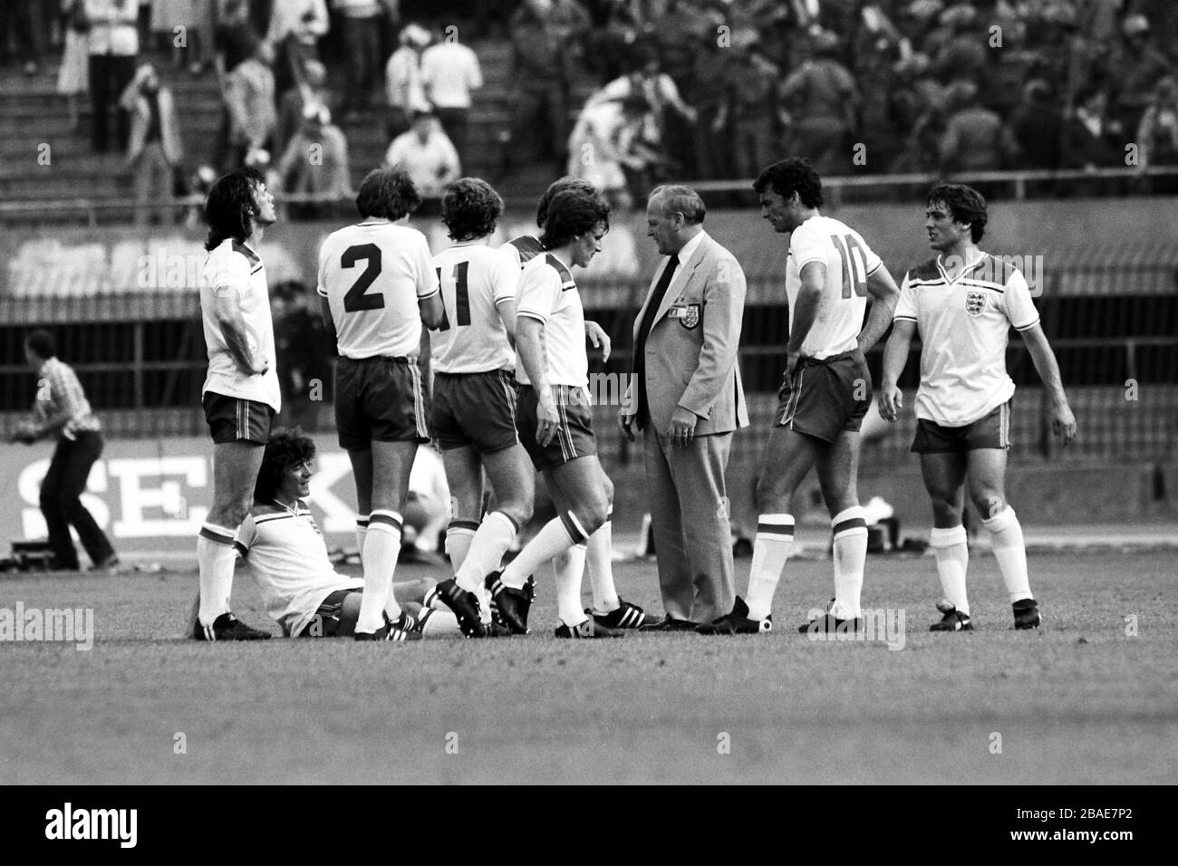 England-Manager Ron Greenwood (drittes r) spricht ein schnelles Teamgespräch mit (l-r) Dave Watson, Phil Neal, Tony Woodcock, Phil Thompson (versteckt), Steve Coppell, Trevor Brooking und Kenny Sansom während eines Hiatus im Spiel, der durch die randalierenden England-Fans verursacht wurde, die von der italienischen Polizei mit Tränengas kontrolliert wurden Stockfoto