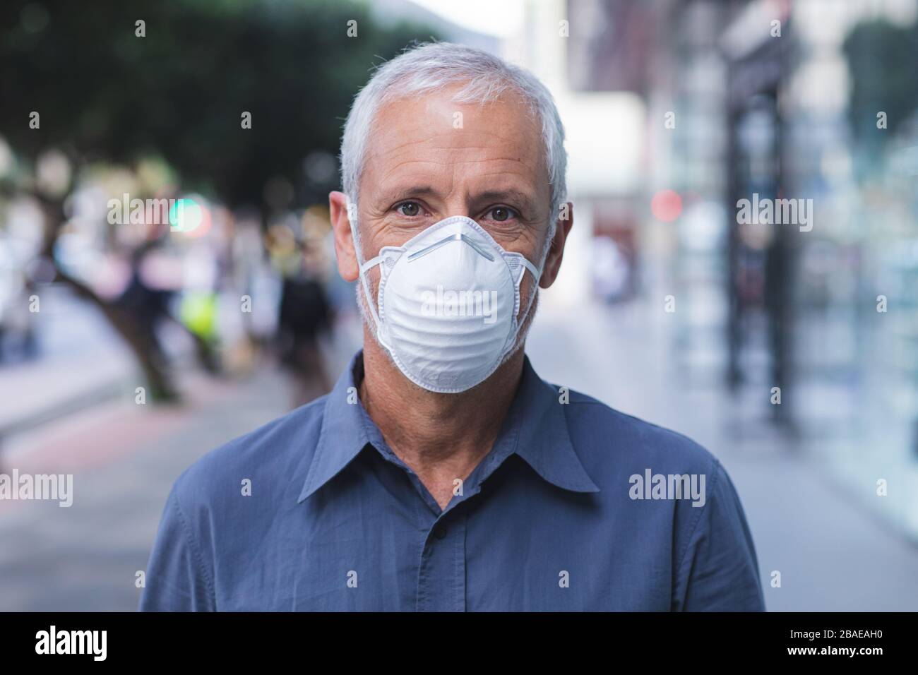 Mann mittleren Alters trägt unterwegs die Maske Coronavirus Covid 19 Stockfoto