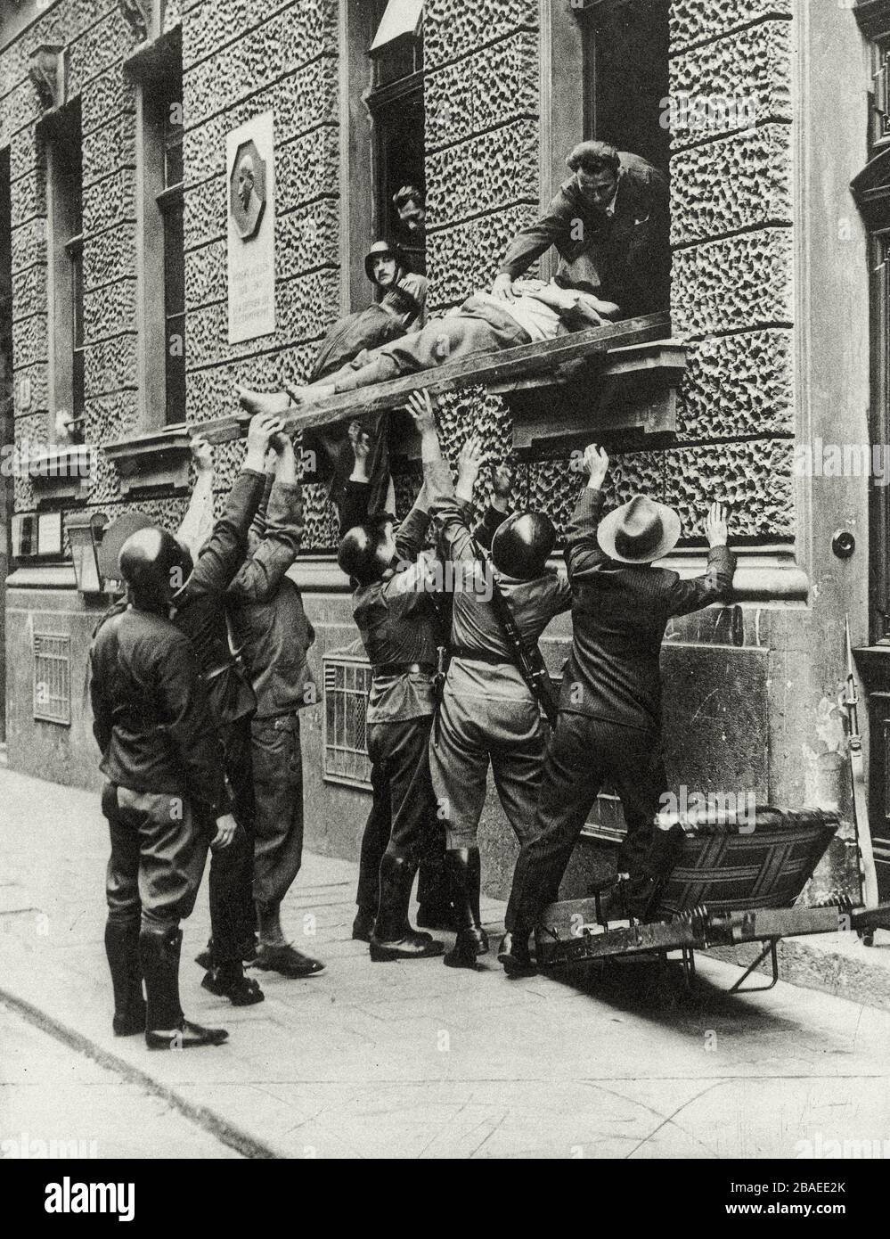 Österreichischen Bürgerkrieg. Polizeibeamte und Angehörige der Heimwehr bei der Erstürmung des Wiener Funkgebäudes. Soldaten tragen den Körper des m aus Stockfoto