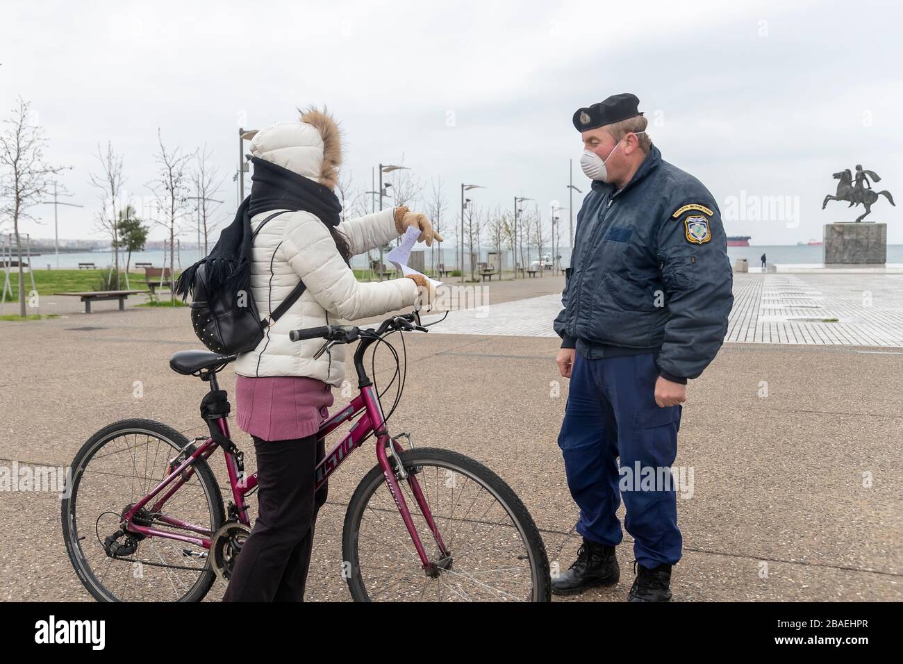 Saloniki, Griechenland - 23. März 2020: Ein Polizeibeamter überprüft die Dokumente eines Bürgers, da das Land die Verbreitung des COVID nicht unter Kontrolle hat Stockfoto